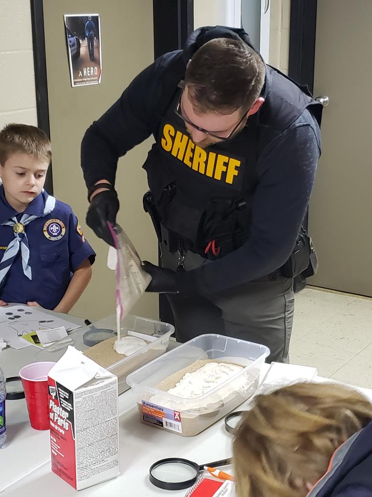 deputy working with scouts at table