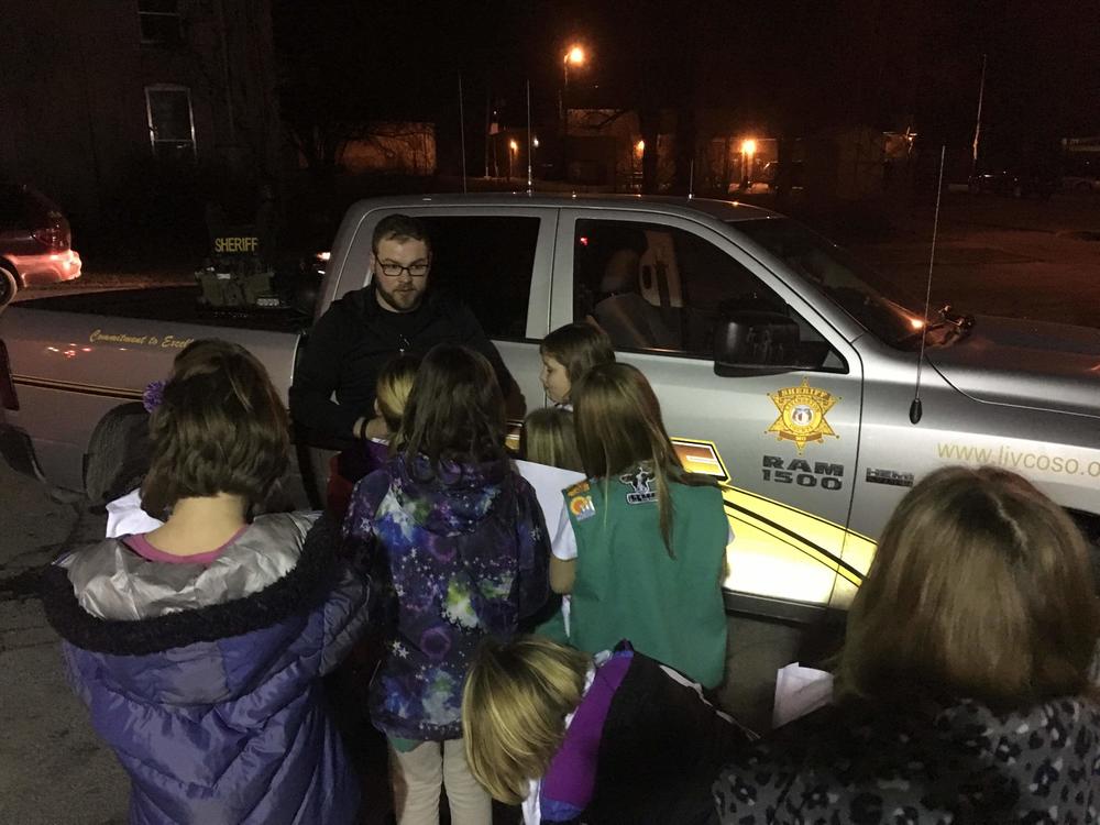 girl scouts standing by patrol vehicle