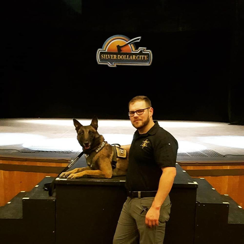 zaki and deputy leadbetter posing in front of Silver Dollar City sign