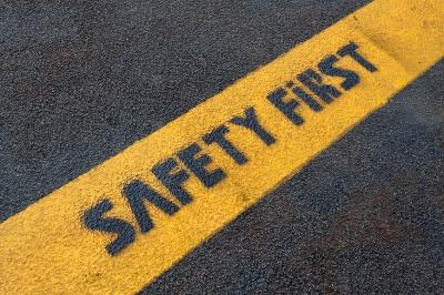 Safety First words written on a yellow stripe on the road
