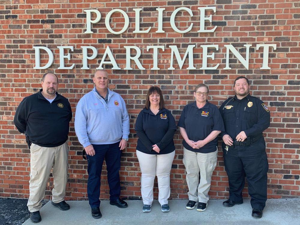 Dispatchers Dena Thomas and Brenda Buck standing with Police Chief Jon Maples, CDES Chief Eric Reeter and Sheriff Steve Cox