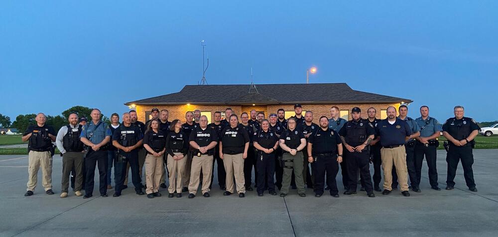 Majority of the law enforcement officer stand together for a group photo.