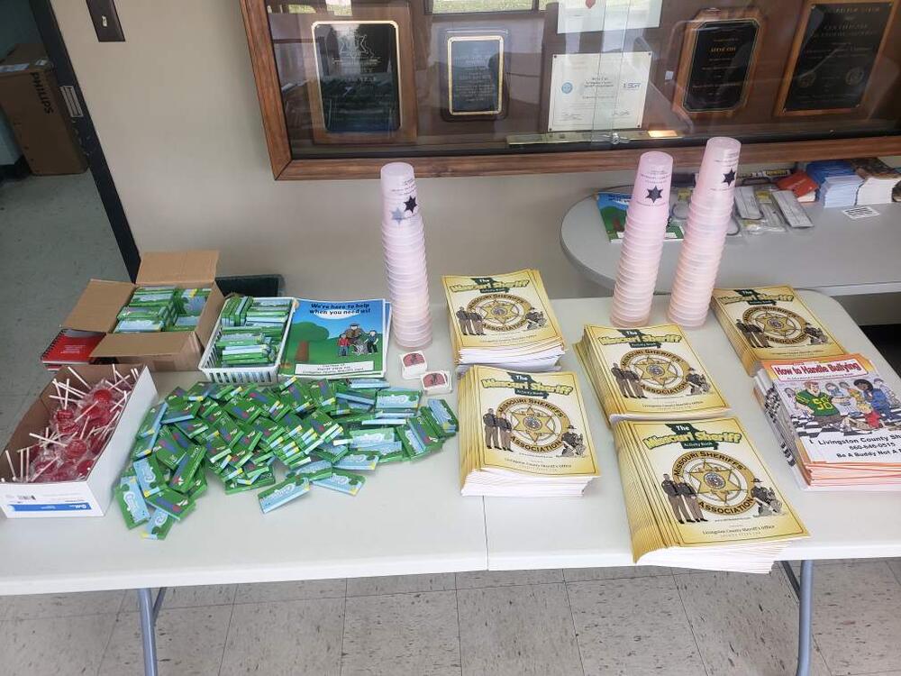 Items featured on this giveaway table are coloring books, mood cups, crayons, and suckers for children.